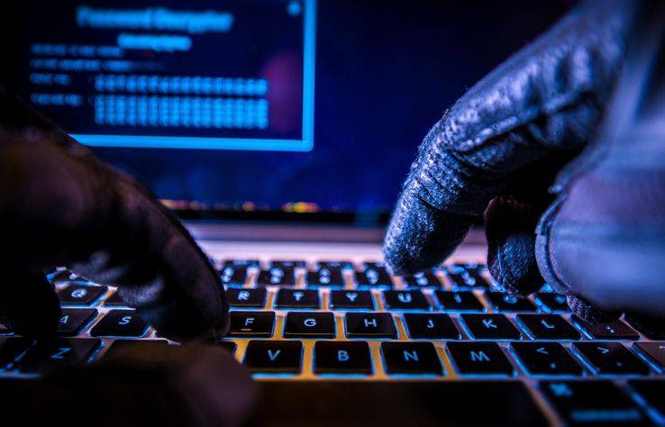 maos-com-luvas-digitando-em-teclado-de-computador