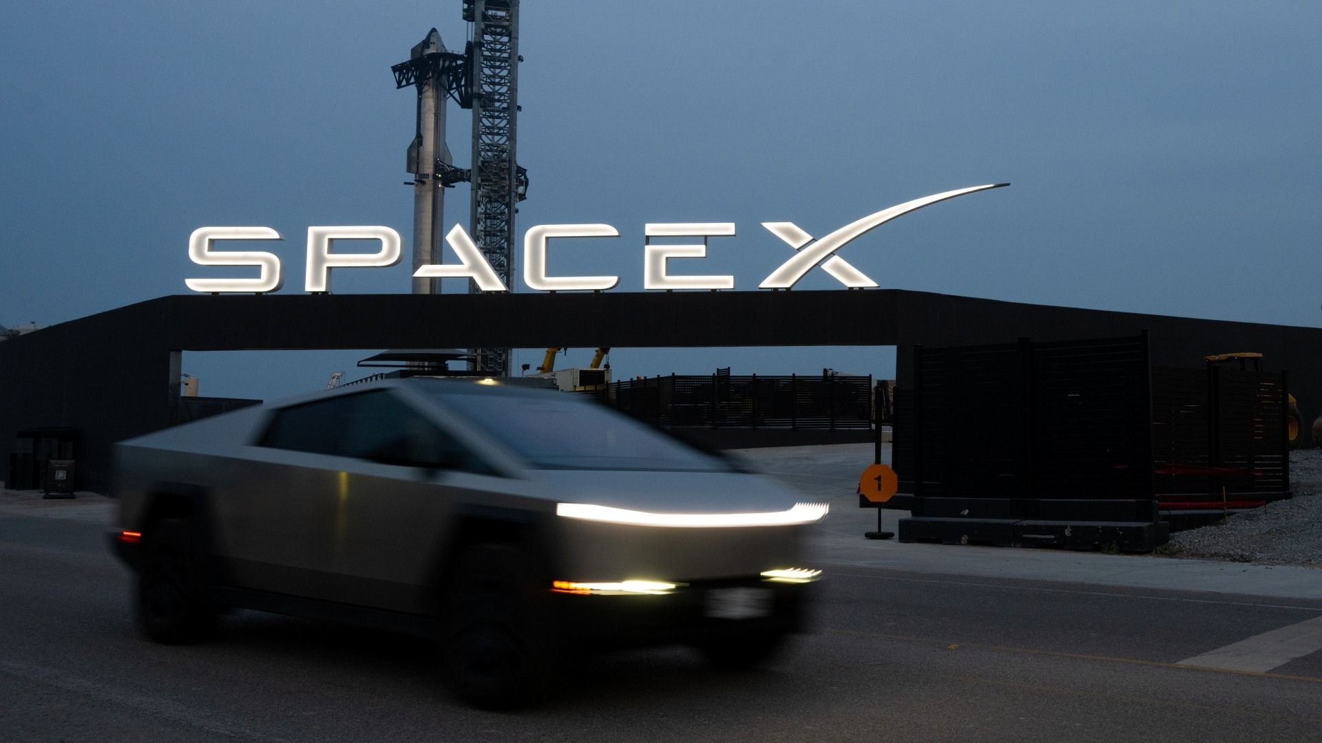 SpaceX avalia investimento na xAI de Elon Musk 2 Elon Musk em frente ao logo da SpaceX, simbolizando o potencial investimento na xAI, sua empresa de inteligência artificial.