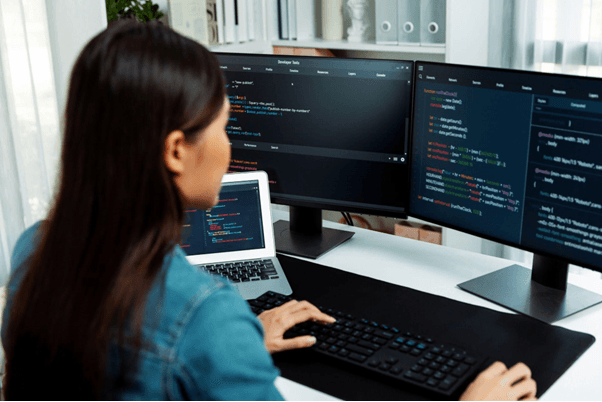 mulher-programadora-escrevendo-código-tela-dupla-tecnologia-vibe-coding-desenvolvimento-de-software