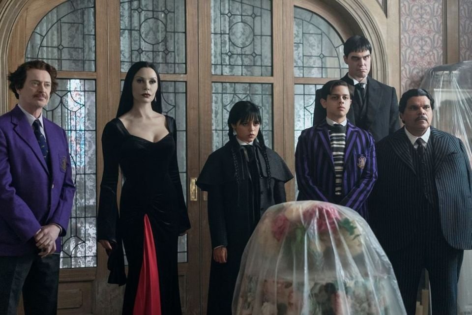 8 séries como Wandinha para ver enquanto espera a terceira temporada Quando a Netflix lançou Wandinha, em 2022, não imaginava que a série iria se tornar um fenômeno global. Protagonizada por Jenna Ortega, a produção trouxe uma nova perspectiva sobre a personagem icônica da Família Addams, misturando humor ácido, mistério sobrenatural e dramas típicos da adolescência. wandinha-elenco-2.JPG