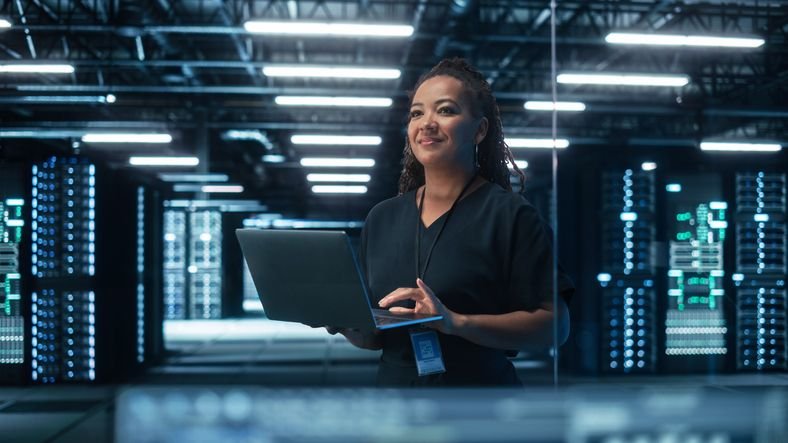 O que é VNC e para que serve essa tecnologia? Controlar um computador a milhares de quilômetros de distância, como se estivesse sentado em frente a ele, é algo que as tecnologias de acesso remoto proporcionam, permitindo realizar diferentes tipos de trabalhos. O VNC é uma dessas ferramentas. mulher-segurando-notebook-em-um-data-center