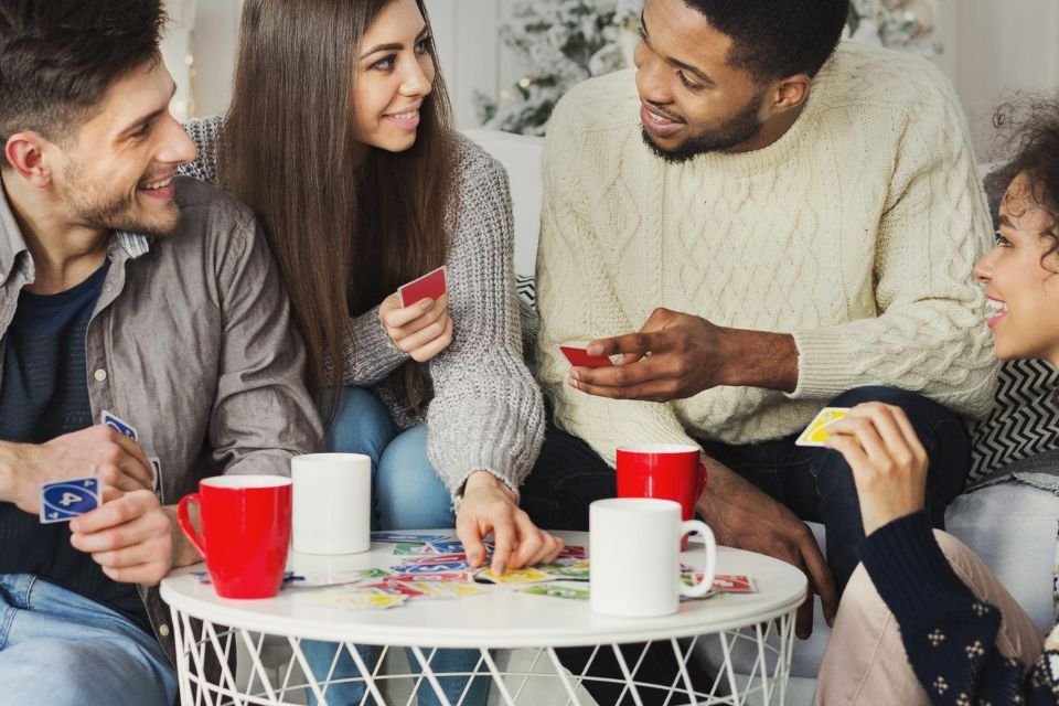 Uno, Dobble e mais: descubra os jogos mais comprados na Amazon Jogos de cartas e tabuleiro continuam conquistando espaço nas casas de famílias e grupos de amigos. Seja para momentos de lazer no fim de semana ou para animar festas e encontros, essas opções garantem risadas e desafios para todas as idades. Grupo de 4 pessoas jogando o jogo de cartas UNO e rindo