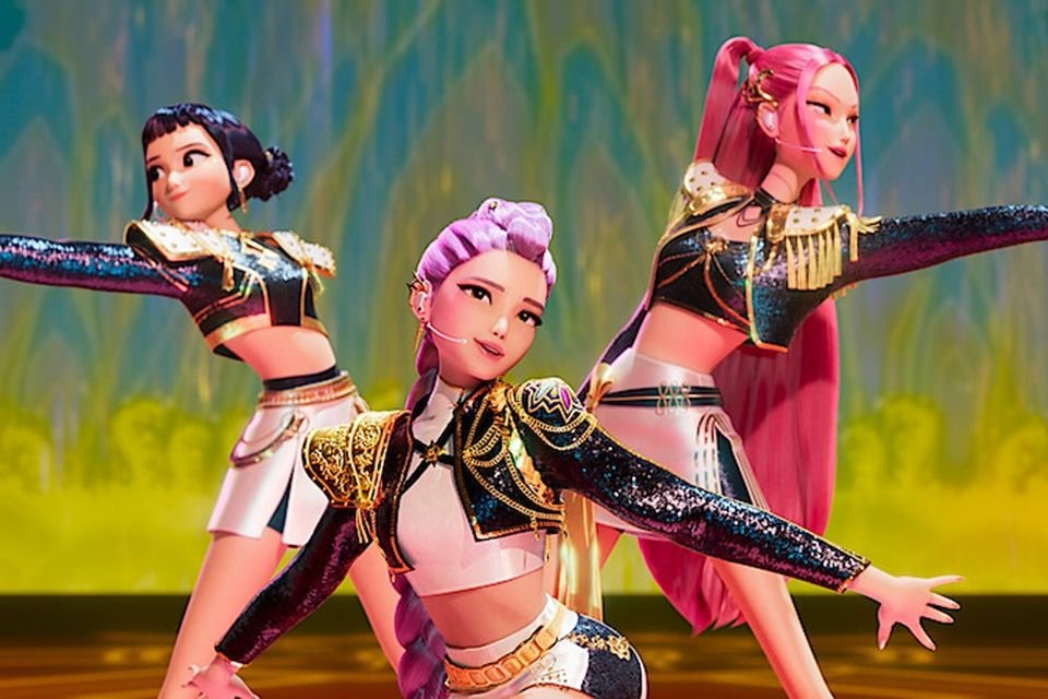 Live action de Kpop Demon Hunters: pode acontecer? O K-pop já se consolidou como um fenômeno mundial, mas, em 2025, ele ganhou uma nova camada de fantasia com a estreia de Kpop Demon Hunters (Guerreiras do K-Pop). personagens-kpop-demon-hunters-em-performance-roupas-brilhantes-cabelo-colorido-coreografia