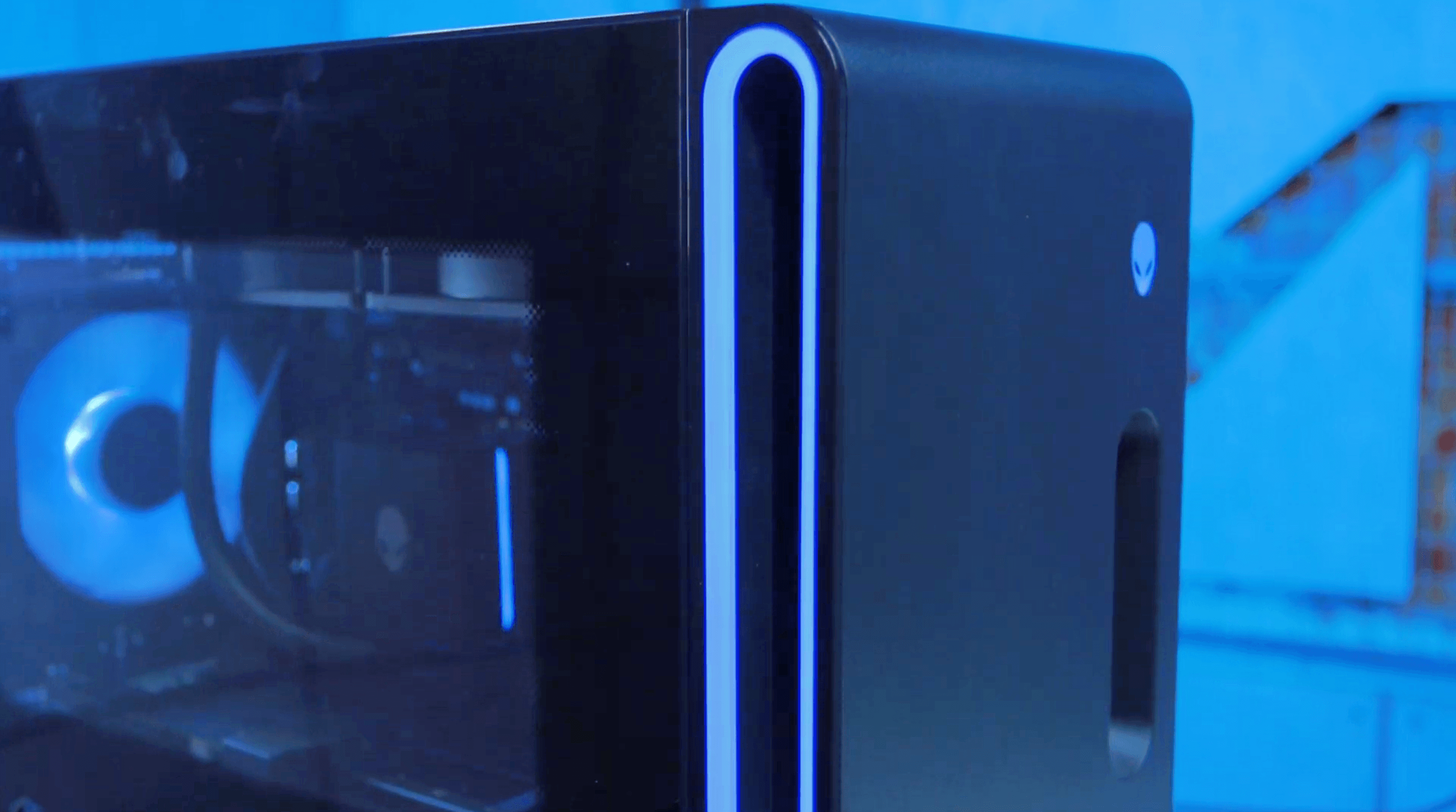 Gabinete do Alienware Aurora 2025 a partir do ângulo diagonal frontal. No centro da imagem, a grande fenda na lateral da frente cercada pelo LED RGB na cor azul