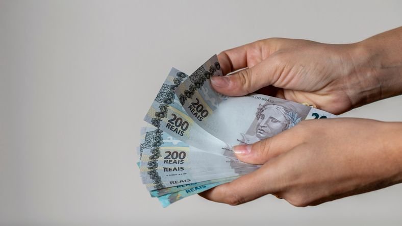 Operação em SP mira estrangeiros que movimentaram R$ 480 milhões em golpes virtuais Uma quadrilha de estrangeiros que praticava golpes virtuais no Brasil foi alvo de operação da Polícia Civil de São Paulo e do Ministério Público nesta quarta-feira (27). A organização criminosa movimentou mais de R$ 480 milhões em oito meses, de acordo com a investigação, fazendo vítimas em todo o país. maos-segurando-notas-de-200-reais
