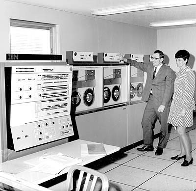 Foto de época mostrando um mainframe com entrada de dados por fitas magnéticas
