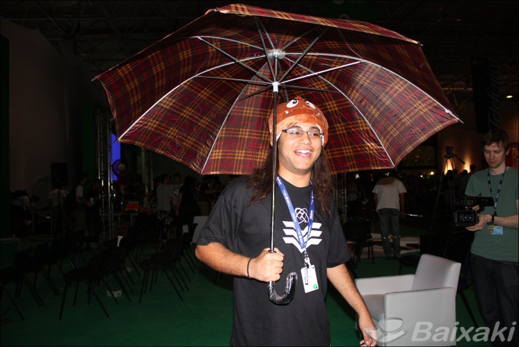 Campuseiro caminha de guarda-chuva na área central do evento